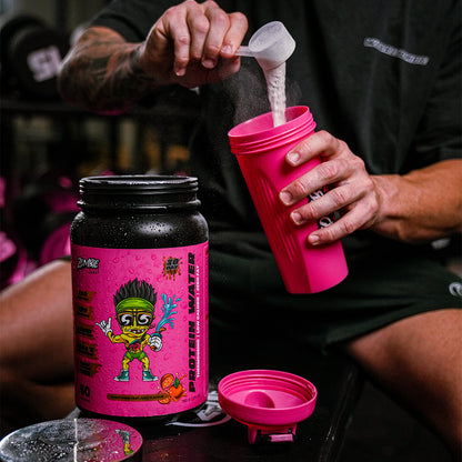 Man emptying a scoop of Zombie Labs Shredz Protein Water into a pink Zombie Labs shaker while sitting on a black gym bench